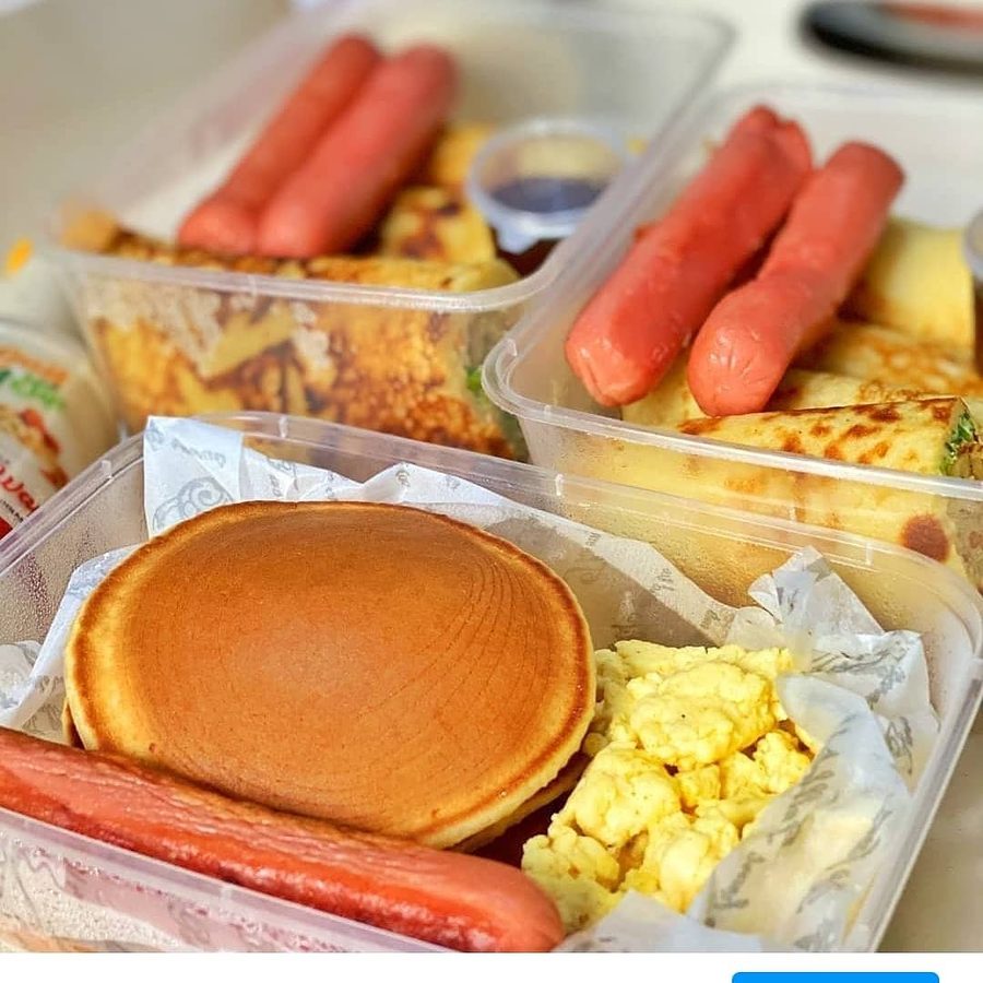 Breakfast boxes with pancakes, eggs and sausages
